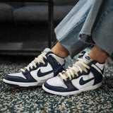 Looped Laces Vintage '85 light yellow cream flat shoelaces in Nike Dunk High Midnight Navy sneakers on shaggy green and beige rug
